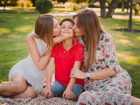 mother and son kiss|Joyful and cute young mom kiss son outdoors. Mother and kid。